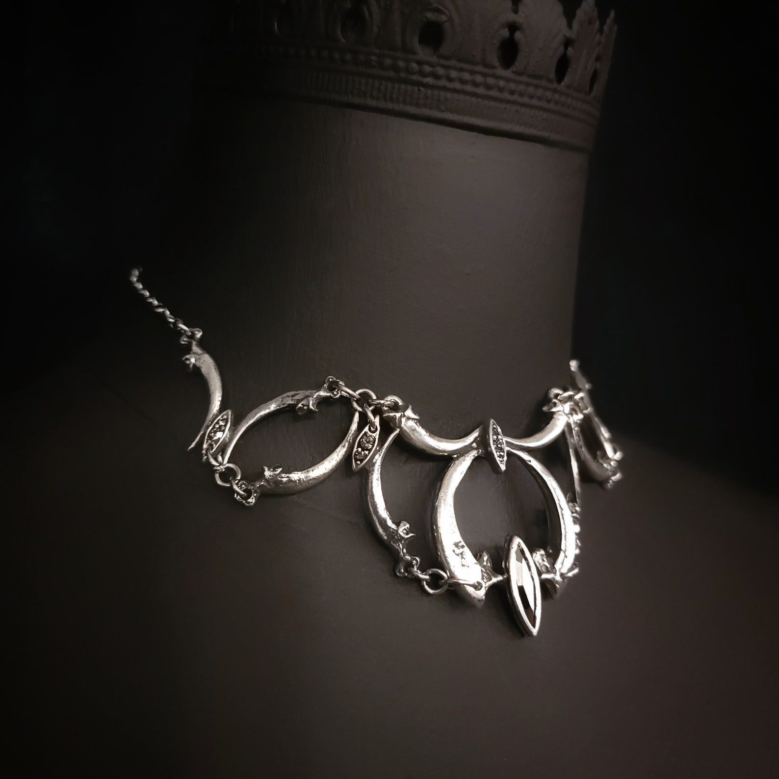 Side angle of claw-shaped goth choker with sculptural bird talons and oxidized silver finish.