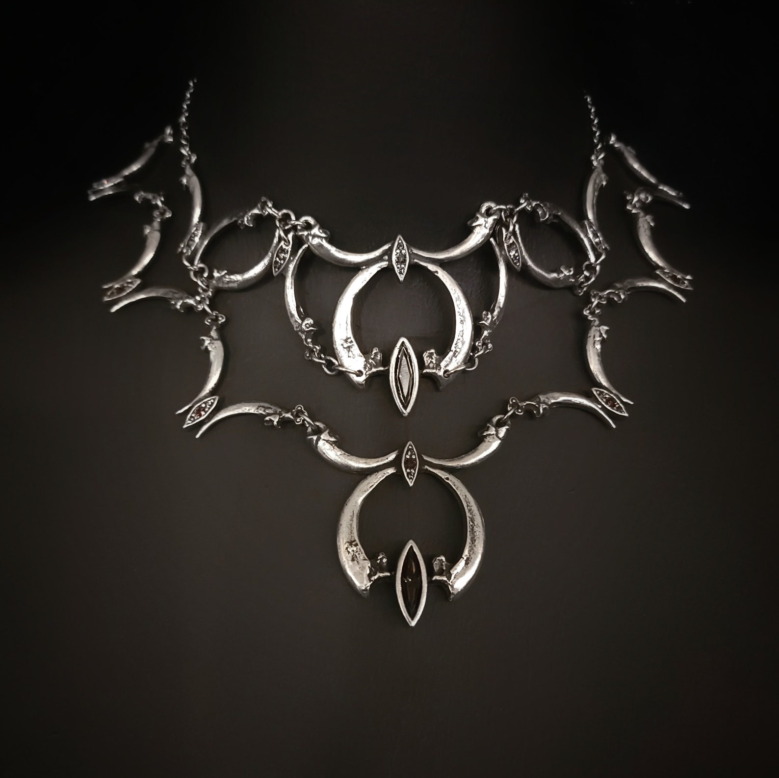 Bird claw goth choker necklace with pewter cast talons and navette crystals arranged in crescent forms.