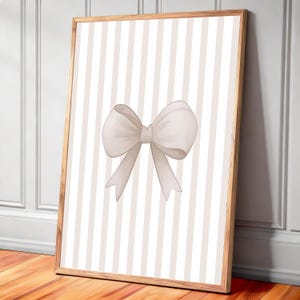 Peut inclure: Impression encadrée avec une illustration à l'aquarelle d'un nœud. Le nœud est d'une couleur neutre et douce, sur un fond de rayures verticales dans un ton similaire. Le cadre est en bois clair.