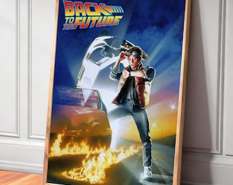 May include: A framed poster featuring the movie "Back to the Future." The poster shows a man in a vest and jeans, standing in front of a car with flames. The movie title is at the top in blue and yellow.