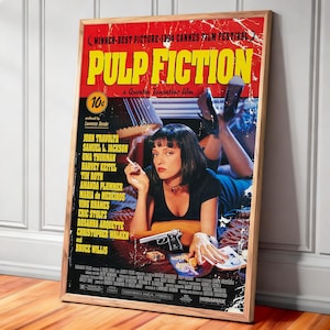 May include: A framed movie poster for "Pulp Fiction" with a red and yellow background. The poster features the film's title, cast, and a central image of a woman with a cigarette. The poster is in a wooden frame.