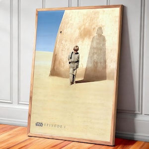 May include: A framed poster featuring a scene from Star Wars: Episode I. The image shows a young boy in a desert landscape with a large shadow resembling Darth Vader. The poster has a wooden frame and the title is at the bottom.