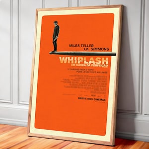 May include: A framed movie poster for "Whiplash" with an orange background. The poster features the names Miles Teller and J.K. Simmons. The title "WHIPLASH" is prominently displayed, along with text in Portuguese. A man in a suit stands on a drumstick.