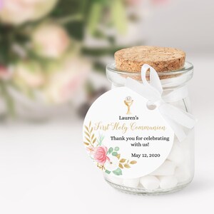 May include: White round favor tag with gold floral design and a gold chalice icon. The tag says "Lauren's First Holy Communion" and "Thank you for celebrating with us! May 12, 2020".