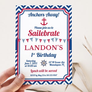 May include: A blue and red nautical themed birthday invitation for Landon's 1st birthday. The invitation features an anchor, a ship's wheel, and a string of red, white, and blue pennants. The text reads "Anchors Away! Please join us to Sailebrate LANDON'S 1st Birthday. Saturday June 7, 2022 at 10:00 am 117 N Ocean Ave Manalapan, FL Lunch will be served RSVP by May 23 to 561.123.4567"