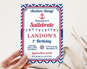 May include: A blue and red nautical themed birthday invitation for Landon's 1st birthday. The invitation features an anchor, a ship's wheel, and a string of red, white, and blue pennants. The text reads "Anchors Away! Please join us to Sailebrate LANDON'S 1st Birthday. Saturday June 7, 2022 at 10:00 am 117 N Ocean Ave Manalapan, FL Lunch will be served RSVP by May 23 to 561.123.4567"