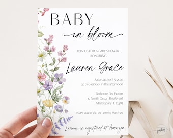 May include: A floral baby shower invitation with a watercolor design of pink, purple, and yellow flowers. The text reads "Baby in Bloom" and includes the name "Lauren Grace" and details for the shower. RSVP by March 29.