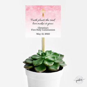 Puede incluir: Un fondo de acuarela rosa y blanco con una cruz dorada y el texto "Faith plants the seed, love makes it grow. Christina's First Holy Communion May 12, 2023".