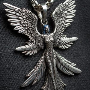 May include: A silver pendant necklace featuring a detailed angel design with outstretched wings. The angel has blue hair and a flowing gown. The necklace chain is also silver and has a textured appearance. The pendant is displayed against a dark background.