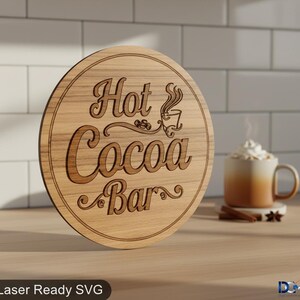 Puede incluir: Un letrero redondo de madera con las palabras "Hot Cocoa Bar" grabadas en una fuente decorativa. El letrero es de color marrón claro y presenta un gráfico de taza de café. Una taza de chocolate caliente con crema batida está en el fondo.