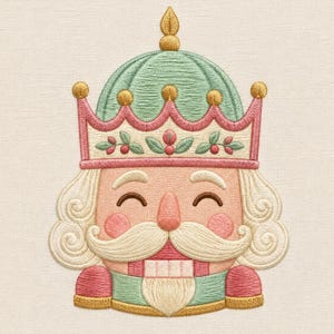 Può includere: Un ricamo raffigurante una testa di schiaccianoci con una corona verde menta con dettagli dorati, un bordo rosa con motivi a foglie, pelle color pesca, guance rosate, baffi bianchi, una barba bianca e una bocca rettangolare con denti bianchi.