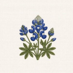May include: Embroidered bluebonnet flower design with green leaves and stems on a cream-colored background. The blue flowers have white accents. The design is centered and detailed, showcasing the flower's petals and buds.