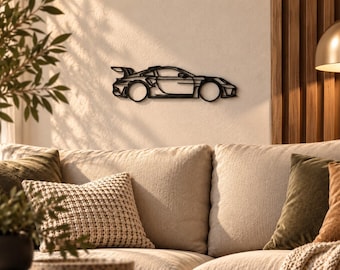May include: A black metal wall art piece shaped like the side profile of a sports car with a rear spoiler. The design features clean, continuous lines outlining the vehicle's body, wheels, and aerodynamic components in a flat, minimalist silhouette.