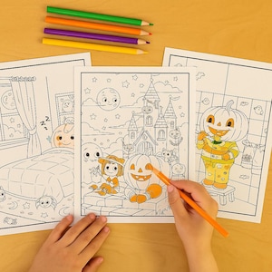 May include: A collection of Halloween-themed coloring pages with illustrations of pumpkins, ghosts, and a haunted castle. Colored pencils in green, orange, purple, and yellow are arranged at the top. A hand is coloring an orange pumpkin on one of the pages.