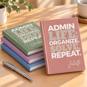 Puede incluir: Una pila de cuatro cuadernos de tapa dura en rosa empolvado, verde salvia, lavanda y azul. Cada cuaderno presenta el texto blanco "ADMIN LIFE: ORGANIZE. SOLVE. REPEAT." y un nombre personalizado en letra cursiva. Un bolígrafo de metal plateado se encuentra cerca.