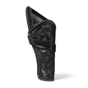Könnte beinhalten: Schwarze Lederholster mit aufwendigen floralen und scrollartigen Verzierungen. Die Holster hat weiße Nähte und einen Lederriemen. Das Design ist im klassischen Western-Stil gehalten und für eine Schusswaffe geeignet.