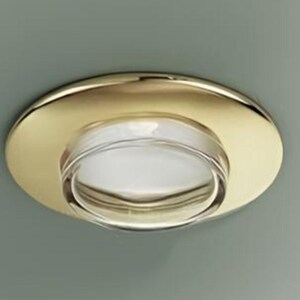 Può includere: Una lampada da soffitto a incasso con bordo circolare in metallo dorato lucido e lente in vetro trasparente. Il design presenta un anello metallico esterno liscio e riflettente che circonda un inserto centrale in vetro trasparente.