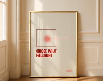 May include: A framed art print with a gold border. The artwork features the text "CHOOSE WHAT FEELS RIGHT" in red, below a red square with a blurred circle and a line. The background is off-white.