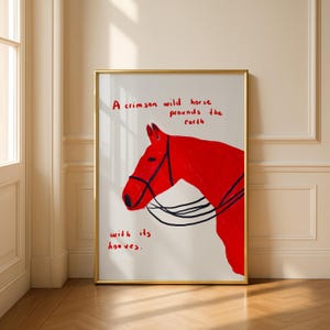 Puede incluir: Una impresión artística enmarcada con una ilustración de un caballo rojo carmesí con detalles de brida negra. La obra de arte incluye el texto "A crimson wild horse pounds the earth with its hooves" en rojo. El marco es dorado.