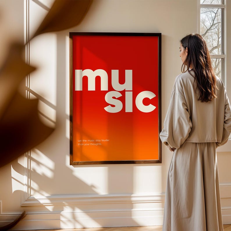 Puede incluir: Un p&oacute;ster enmarcado con la palabra "MUSIC" en letras blancas grandes sobre un fondo degradado rojo y naranja vibrante. El p&oacute;ster tambi&eacute;n incluye el texto "Let the music stay louder than your thoughts." El marco es negro.