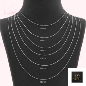 Puede incluir: Exhibici&oacute;n de collares de cadena plateada de varias longitudes, de 35,5 cm a 61 cm, sobre un maniqu&iacute; negro. Cada cadena est&aacute; etiquetada con su longitud en pulgadas. El logotipo de Zarisha est&aacute; en la esquina inferior derecha.