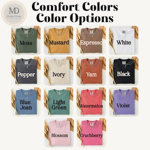 以下が含まれることがあります： Moss、Mustard、Espresso、White、Pepper、Ivory、Yam、Black、Blue Jean、Light Green、Watermelon、Violet、Blossom、Crunchberryとラベル付けされた14枚のクルーネックTシャツのカラーチャート。Comfort Colors Color Optionsというテキストが表示されています。
