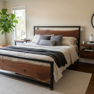 May include: A modern bedroom featuring a bed with a dark metal frame and a natural wood headboard and footboard. The bed is made with neutral-colored bedding and gray pillows. A dark gray throw blanket is draped across the foot of the bed. A large green plant sits near the window.