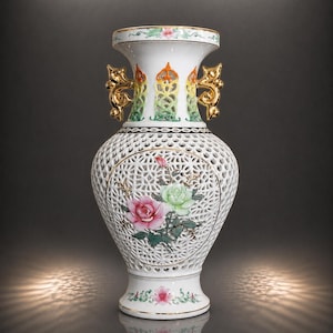 Pode incluir: Um vaso de porcelana branca com um intrincado padrão de treliça aberta, alças pintadas a ouro e um medalhão central pintado com rosas cor-de-rosa e verdes. A borda e a base são decoradas com motivos florais e finos detalhes dourados.