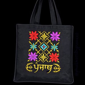 Peut inclure: Sac fourre-tout noir avec broderie florale rouge, violette, jaune et turquoise. Le motif comprend un motif de losanges et du texte doré. Le sac a deux anses noires.