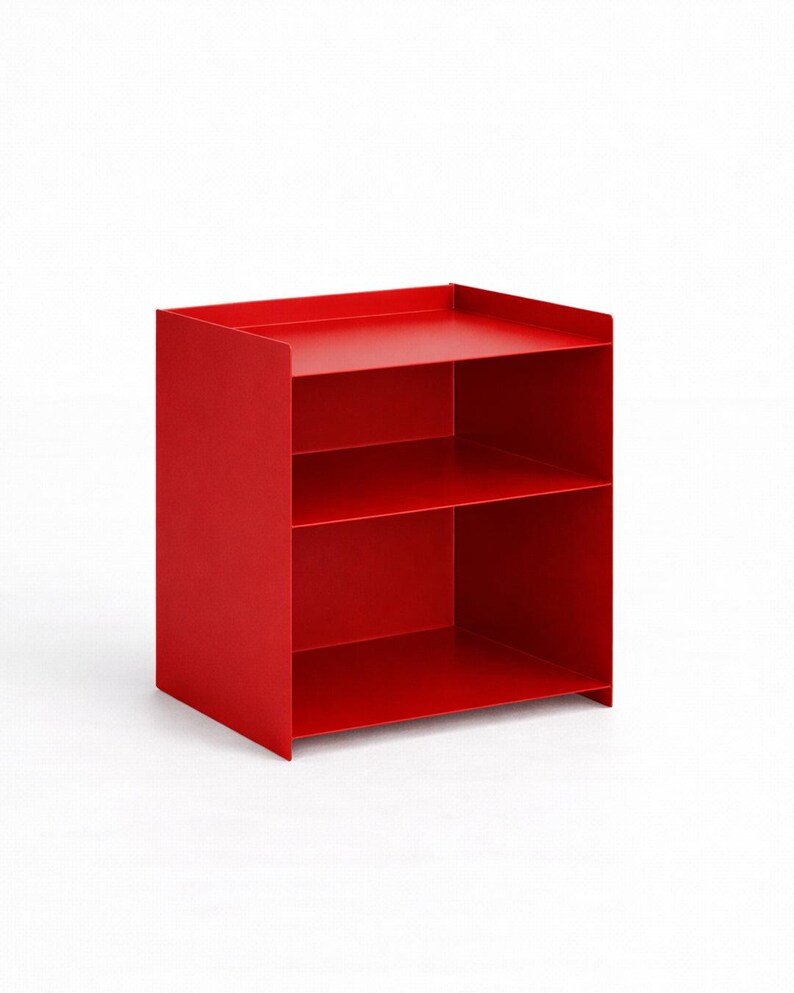 Puede incluir: Una unidad de almacenamiento de metal rojo brillante con un marco rectangular, dos estantes abiertos y un borde elevado en la superficie superior. La estructura est&aacute; compuesta por paneles finos y s&oacute;lidos con un acabado liso.