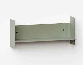 Puede incluir: Un estante de pared de metal color verde salvia que cuenta con una superficie horizontal plana, un panel trasero vertical y dos paneles laterales. El estante se fija a la pared con dos tornillos negros visibles en el panel trasero.