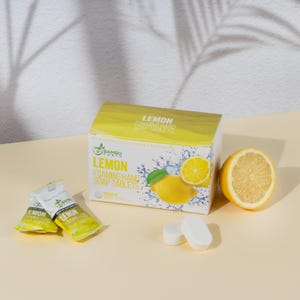 May include: A box of Lemon Foaming Hand Soap Tablets with a lemon graphic, two individual soap tablets, and a halved lemon. The packaging is white and yellow, with the brand name "Bambo Earth".