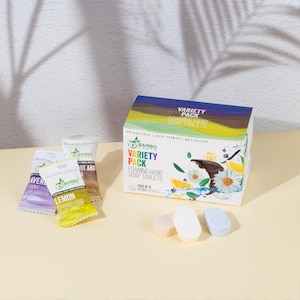 May include: A variety pack of foaming hand soap tablets. The box features the text "Variety Pack" and illustrations of flowers and fruit. Several individual soap tablets and packets are also visible, with flavors like lemon and lavender.