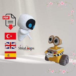 May include: Two crochet figures of the characters Eve and Wall-E from the animated film. Eve is white with a black oval face and blue eyes. Wall-E is yellow with large brown eyes and treads. The image also includes a PDF icon and flags.