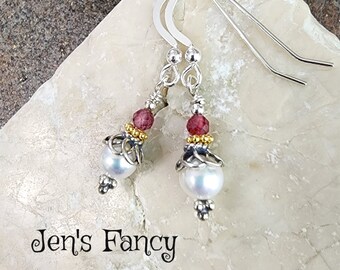 May include: Silver dangle earrings with a white pearl, gold beads, and a pink gemstone.