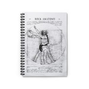 Puede incluir: Cuaderno de espiral con el título "ROCK ANATOMY". La portada presenta una ilustración en blanco y negro de una figura sosteniendo una guitarra, inspirada en el Hombre de Vitruvio de Leonardo da Vinci.