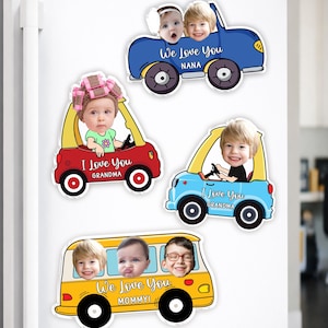 May include: A collection of colorful car and bus-shaped magnets with children's faces. Each magnet has a message like "We Love You" and "I Love You" with names like "Grandma" and "Mommy". The magnets are on a white refrigerator.
