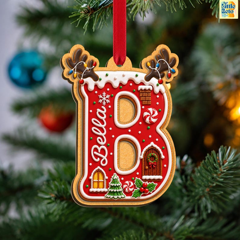 May include: A letter B shaped Christmas ornament with a gingerbread texture, red icing, and white trim. It features the name Bella, a small house, a chimney, a Christmas tree, holly, and reindeer antlers with colorful lights, hanging by a red ribbon.