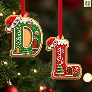 May include: Two hanging Christmas ornaments shaped like the letters D and L, designed to look like gingerbread cookies. The green D features the name Daniel and the year 2026, while the red L features the name Lucia and the year 2026.