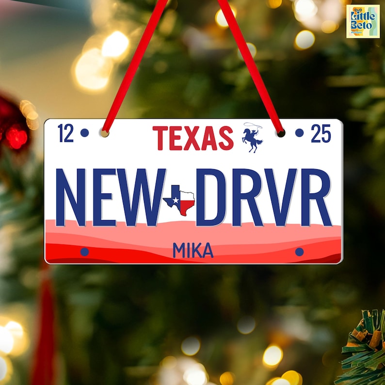 May include: A rectangular Christmas ornament resembling a Texas license plate. The ornament features the text "TEXAS" in red, "NEW DRVR" in blue, and "MIKA" in white. It is adorned with a red and white border and a red ribbon for hanging.