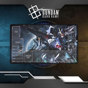 May include: Gundam Card Game playmat featuring a detailed illustration of a Gundam robot in shades of blue, gray, and red against a space-themed background. The playmat has designated zones for cards, including "Base," "Shields," and "Resource Deck."