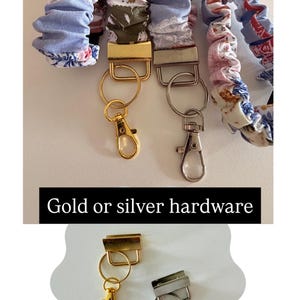 May include: Several fabric lanyards featuring floral and patterned designs in blue, pink, and white. Each lanyard includes a metal clasp and ring, available with either gold or silver hardware. The text "Gold or silver hardware" is visible.