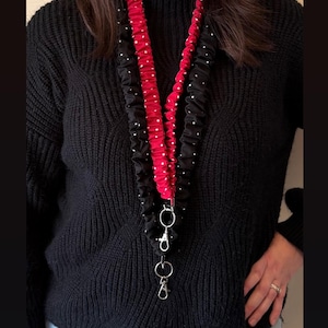 May include: Two fabric lanyards, one black with white polka dots and one solid red, both featuring a ruffled texture and silver-tone metal hardware. Text states: Black lanyard = 41 inches, Red lanyard = 35 inches, and Model is 5'10 inches.