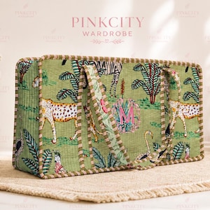 May include: Green tote bag with a jungle animal print featuring cheetahs, zebras, and flamingos. The bag has a rectangular shape with two handles and is trimmed with a striped border. The text "PINKCITY WARDROBE" is visible at the top.