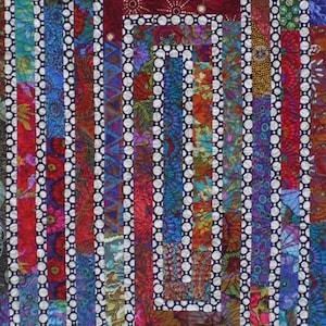 May include: A colorful quilt with a pattern of concentric squares made from strips of fabric. The fabric is a variety of colors and patterns, including red, blue, green, and purple. The quilt is made with a white background and a black polka dot pattern.