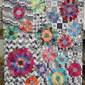 May include: A quilt with a black and white background featuring colorful flower-shaped designs. The quilt is made with a variety of fabrics and textures.