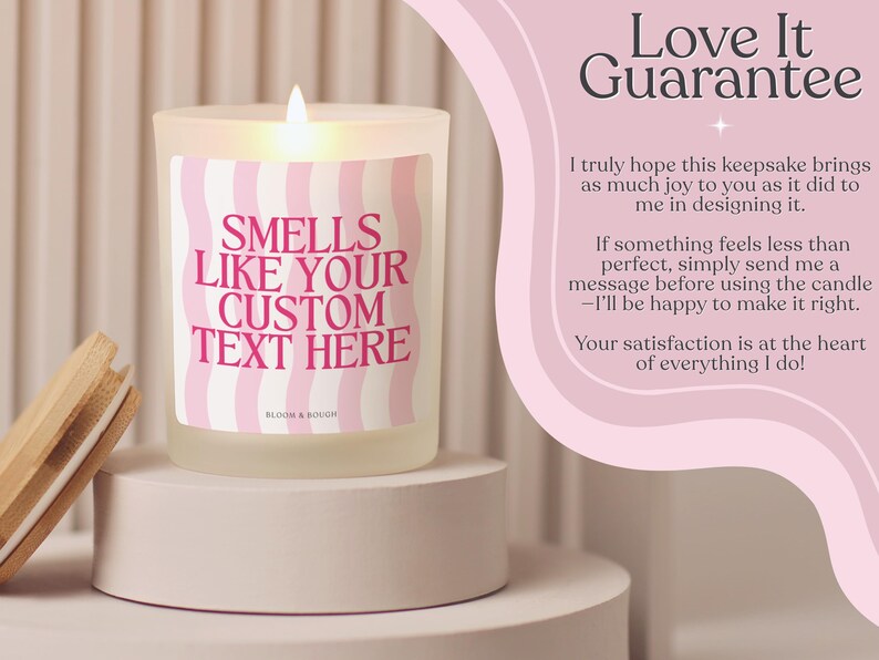 Puede incluir: Una vela encendida en un tarro de vidrio esmerilado con tapa de madera. La vela tiene una etiqueta ondulada rosa y blanca que dice "SMELLS LIKE YOUR CUSTOM TEXT HERE". La vela est&aacute; sobre un pedestal blanco.