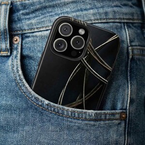 May include: A black smartphone case with a design of silver-colored strings, partially visible in a denim pocket. The case has a glossy finish and a camera module with multiple lenses.