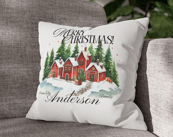 May include: White decorative pillow with a watercolor illustration of red houses, snow, and evergreen trees. The text "Merry Christmas!" and "From The Anderson Family" are printed on the pillow.