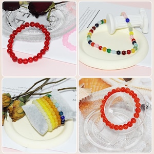 May include: A collection of gemstone bracelets in various colors, including red, yellow, and multicolored beads. The bracelets are displayed on a white surface and clear glass plates, showcasing their vibrant hues and textures. The beads appear to be approximately 0.3 inches in diameter.
